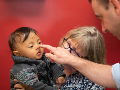 Dr. Hoppe touches the nose of a young boy during a clinic visit.